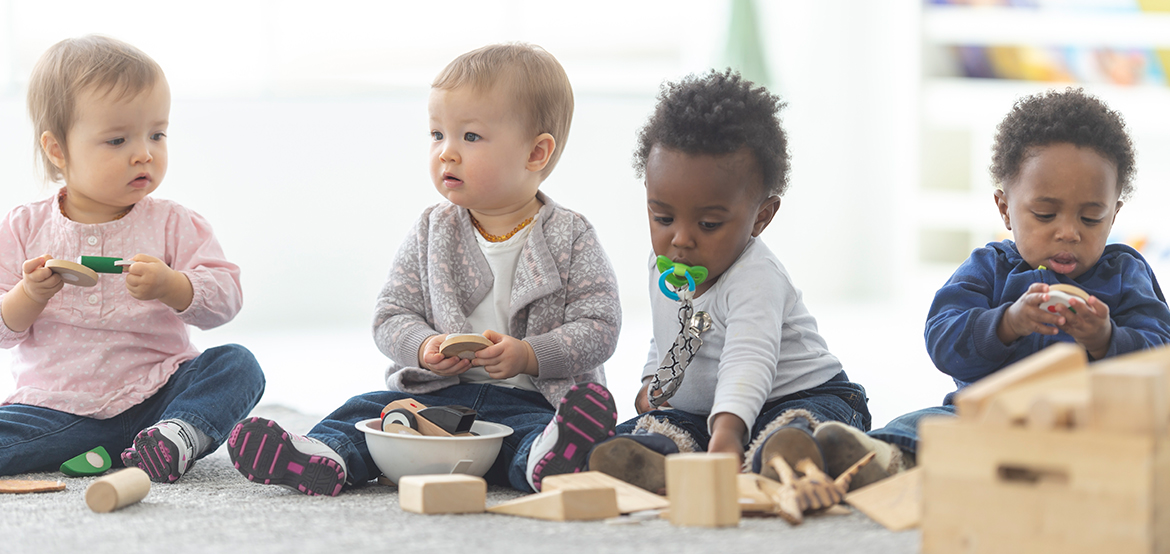 young babies playing with blocks and toys